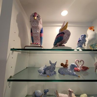 Collection of Herend porcelain figurines, featuring various birds and animals with the signature fishnet pattern and gold accents,...