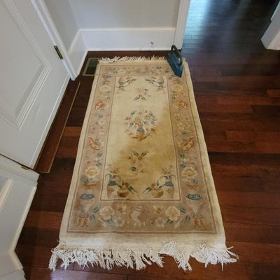 Vintage Chinese Art Deco style wool runner rug featuring floral and urn motifs on a beige field with fringed ends.