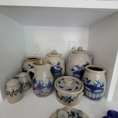 Collection of Salmon Falls stoneware pottery featuring blue hand-painted designs, including canisters, a pitcher, and shakers.