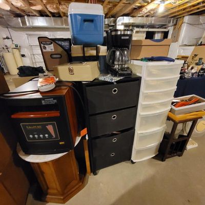 Assorted household items including an EdenPURE portable heater, a black fabric drawer storage unit, a plastic rolling cart, and a Black...