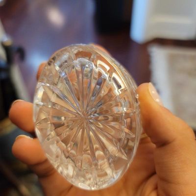 Close-up of the starburst-cut base on a vintage crystal decanter stopper or small dish, showing intricate geometric facets.