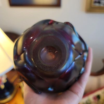 Bottom view of an iridescent art glass vase, showing a faint signature or maker's mark on the polished pontil.