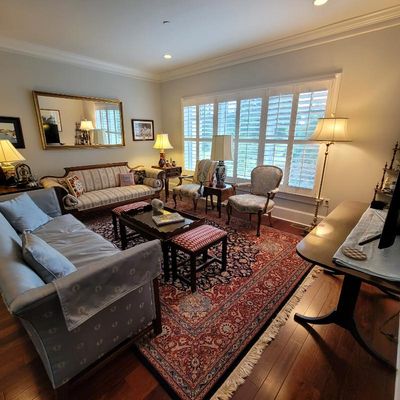Traditional living room furniture set including a light blue upholstered sofa, a striped camelback sofa, two armchairs, a wooden coffee...