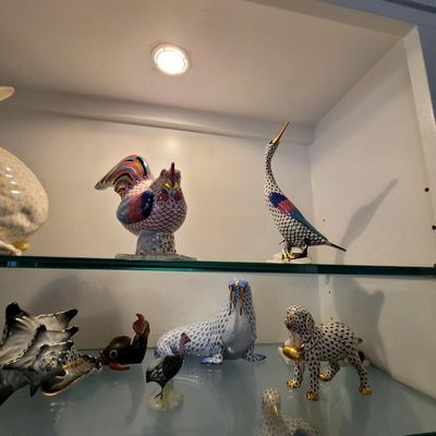 Collection of Herend porcelain animal figurines, including a rooster, heron, walrus, and dog, featuring the signature hand-painted...