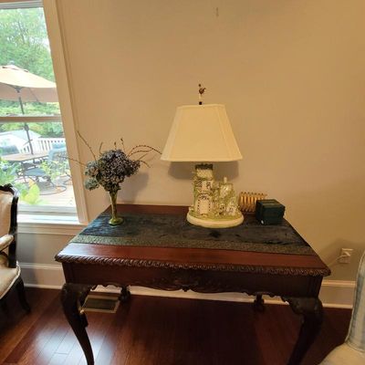 Chippendale-style mahogany library table featuring carved gadroon trim and cabriole legs, styled with a decorative cottage-form table...