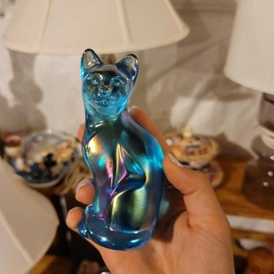 Fenton blue carnival glass cat figurine, featuring an iridescent finish with gold and purple highlights.