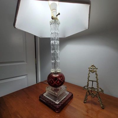 Vintage table lamp featuring a fluted clear glass column, a cut-to-clear cranberry glass orb, and a tiered glass base, paired with a...