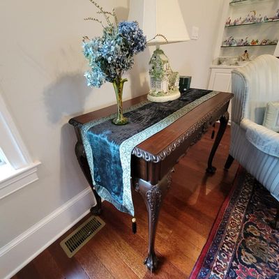 Chippendale-style mahogany console table featuring carved gadroon trim, cabriole legs, and ball-and-claw feet, styled with a velvet table...