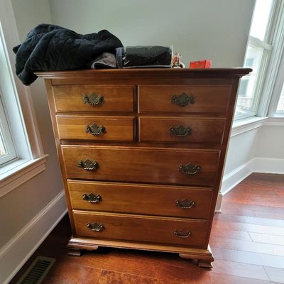 Traditional cherry wood tallboy chest of drawers featuring ornate brass batwing pulls and bracket feet.