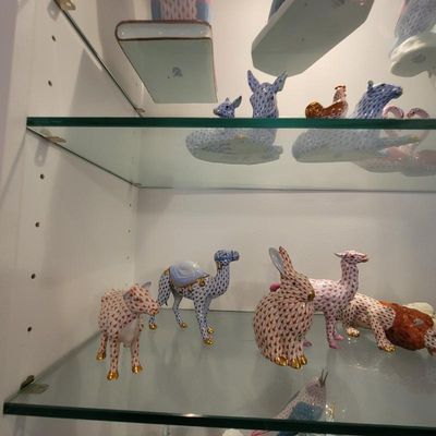Collection of Herend porcelain animal figurines, featuring their signature hand-painted fishnet pattern and 24k gold accents, displayed...
