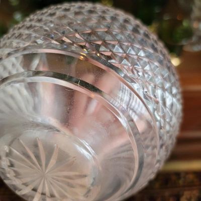 Close-up of a cut crystal bowl showing a diamond pattern on the body and a starburst design on the base.