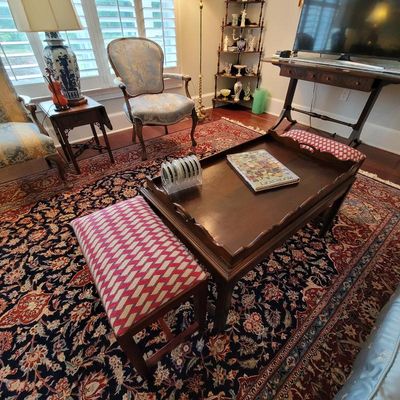 Traditional wooden butler's tray coffee table flanked by two matching benches upholstered in a red and white geometric pattern, set...