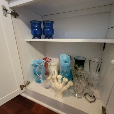 Collection of vintage glassware and vases, including a white ceramic tulipiere, blue opalescent glass pitchers, and clear cut-glass...
