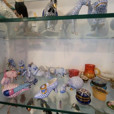 Collection of Herend porcelain figurines, featuring various animals and a shoe in the signature fishnet pattern, displayed alongside...