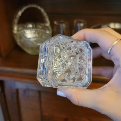 Vintage cut crystal lidded trinket box with a geometric diamond pattern, shown held in hand.