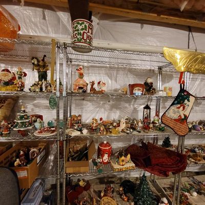 Assortment of vintage and contemporary Christmas decorations, including figurines, stockings, and tabletop displays, arranged on wire...