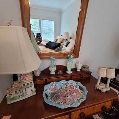Vintage wooden vanity dresser with an attached mirror, displaying a collection of decorative items including a hand-painted floral...