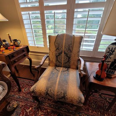 Traditional upholstered armchair featuring a blue and gold damask stripe pattern, wooden armrests, and cabriole legs.