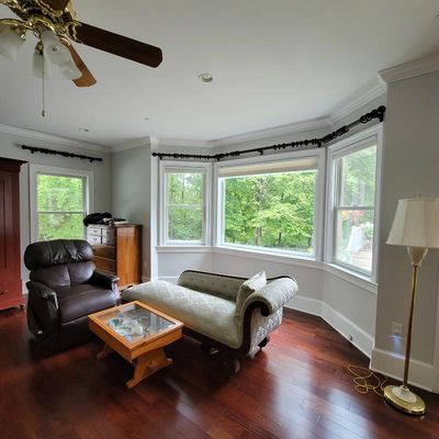 Traditional living room furniture including a brown leather recliner, a light green upholstered chaise lounge, a glass-top coffee table,...
