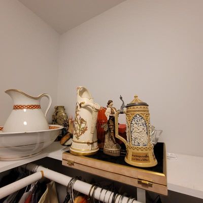 Collection of vintage ceramics including a wash basin and pitcher set, a decorative floral pitcher, a figurine, and a lidded German beer...