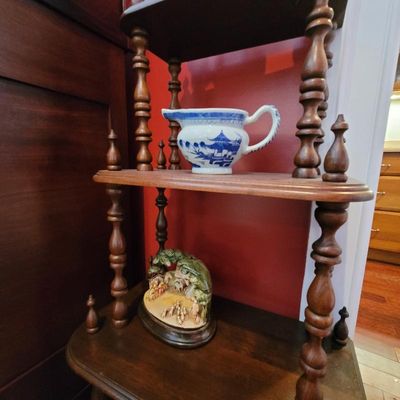 Vintage wooden tiered shelf unit featuring turned spindle supports, displaying a blue and white transferware pitcher and a small...