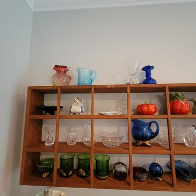 Collection of vintage glassware and ceramics, including cut glass vases, colorful pitchers, and decorative pumpkin-shaped dishes,...