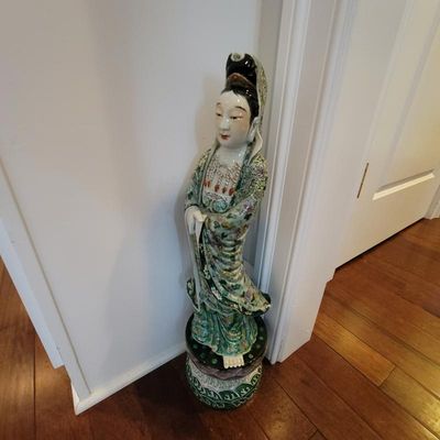 Vintage Chinese porcelain Guanyin statue standing on a decorative pedestal, featuring intricate green and floral glazed robes.