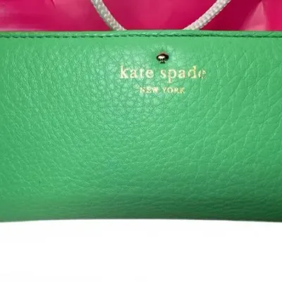 Kate Spade New York green pebbled leather continental wallet with gold-tone logo lettering and spade stud.