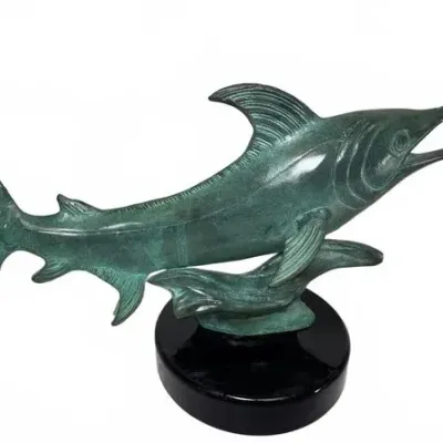 Patinated bronze swordfish sculpture mounted on a polished black marble base, depicting the fish leaping over a wave.