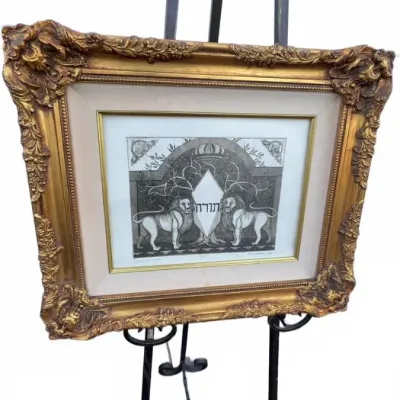 Framed Judaica print depicting the Lions of Judah flanking a central emblem with Hebrew text, housed in an ornate, gilded rococo-style...