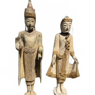 Pair of vintage Southeast Asian style carved wooden standing Buddha statues with distressed paint and gilt details.