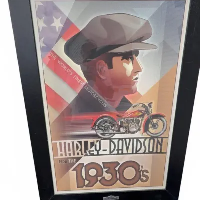 Framed Harley-Davidson promotional poster featuring 1930s-style graphics, displayed on a black metal easel.