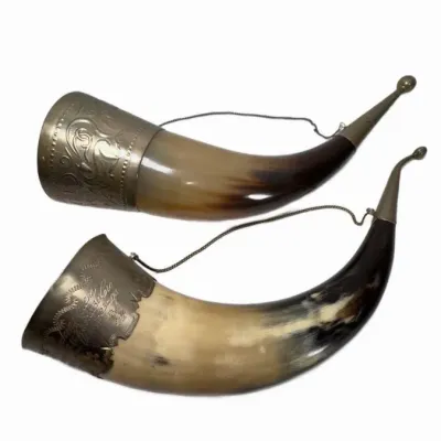 Pair of vintage Caucasian drinking horns featuring ornate metal collars with engraved details and hanging chains.