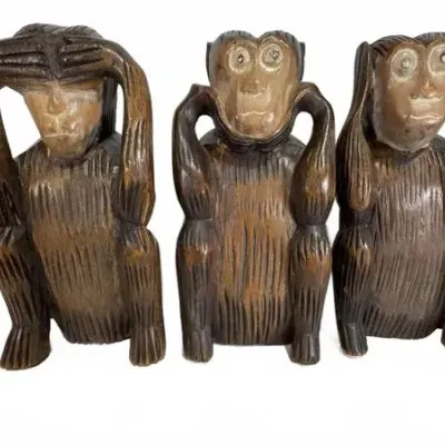 Set of three hand-carved wooden wise monkey figurines representing "see no evil, hear no evil, speak no evil," featuring...