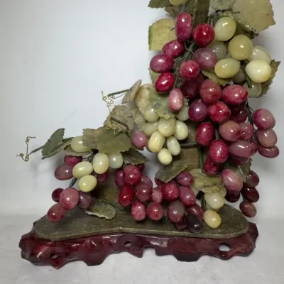 Vintage Chinese carved jade and agate grape cluster sculpture, mounted on a carved wooden base.