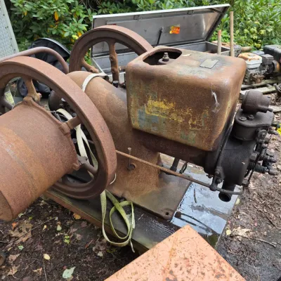 Sale Photo Thumbnail #17: Vintage International Harvester hit-and-miss engine, showing heavy surface rust and wear, mounted on a wooden base.
