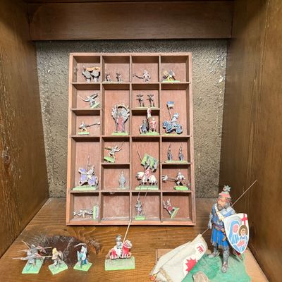 Collection of vintage hand-painted lead and metal toy soldiers, including knights and medieval infantry, displayed in a wooden shadow box...