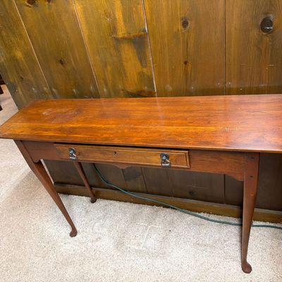Antique Queen Anne style cherry console table featuring a single drawer with brass drop pulls and slender cabriole legs.