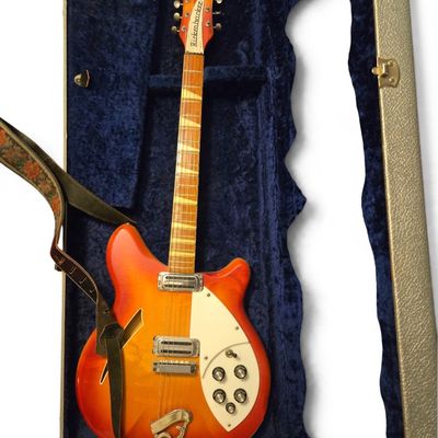 Vintage Rickenbacker semi-hollowbody electric guitar in a Fireglo finish, resting inside a blue velvet-lined hard-shell case with an...