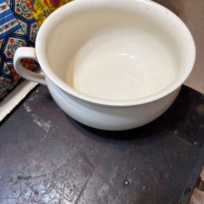 Sale Photo Thumbnail #190: Vintage white ceramic chamber pot with a single handle, showing minor wear and discoloration consistent with age.