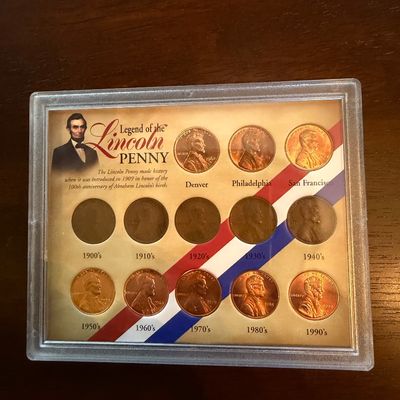 Sale Photo Thumbnail #240: "Legend of the Lincoln Penny" collector's coin set, featuring thirteen Lincoln cents organized by mint mark and decade from the 1900s through the 1990s in a protective plastic display case.