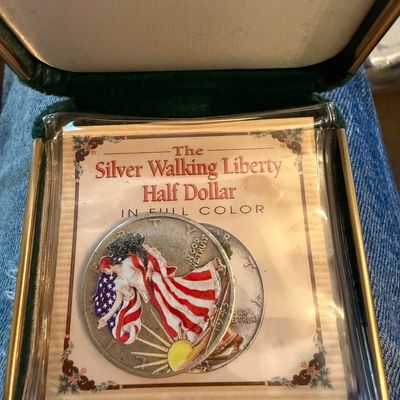 Sale Photo Thumbnail #206: Colorized 1943 Walking Liberty silver half dollar coin, housed in a protective plastic sleeve with its original display card and presentation box.