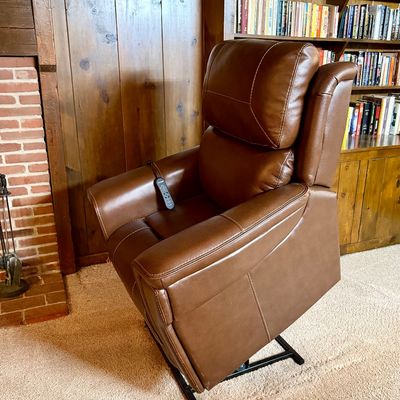 Modern brown leather power lift recliner with wired remote control, shown in the lifted position.