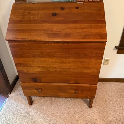 Mid-century modern style knotty pine slant-front secretary desk with a single bottom drawer and tapered legs.