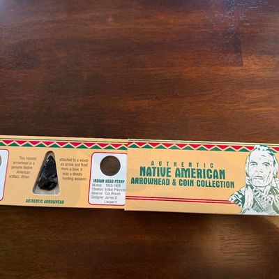 Sale Photo Thumbnail #232: Authentic Native American Arrowhead & Coin Collection set, featuring a Buffalo Nickel, an Indian Head Penny, and a black stone arrowhead in its original display packaging.