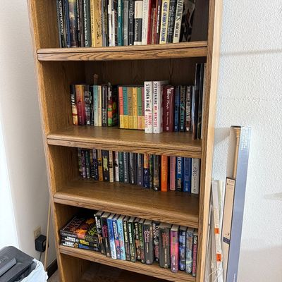 Sale Photo Thumbnail #188: Five-shelf oak bookcase filled with a variety of books, including fiction, history, and reference titles.