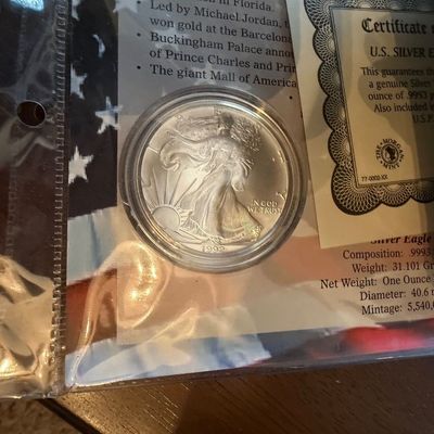 Sale Photo Thumbnail #209: A 1992 U.S. Silver Eagle dollar coin, housed in a protective plastic capsule and accompanied by its certificate of authenticity.