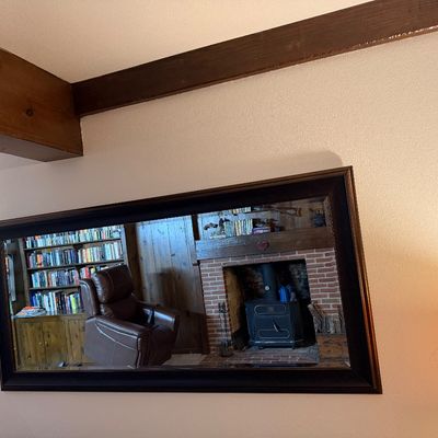 Sale Photo Thumbnail #104: Large rectangular wall mirror featuring a dark wood frame with a gold inner lip, reflecting a cozy living room scene.