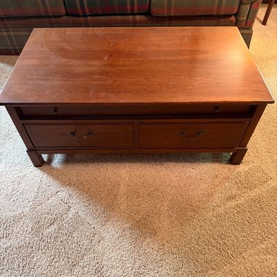 Sale Photo Thumbnail #102: Traditional cherry-finished wood coffee table featuring two storage drawers with brass-toned hardware and a pull-out tray.