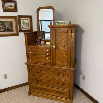 Sale Photo Thumbnail #198: Vintage oak gentleman's chest featuring a built-in vanity mirror, small drawers, a cabinet with diagonal wood paneling, and three large lower drawers.